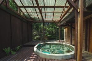 a hot tub on a deck with a roof at Kussharoko Artemina Log Terrace in Kotan