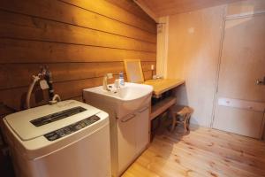 a small bathroom with a sink and a toilet at Artemina Kussharoko Log Terrace in Teshikaga