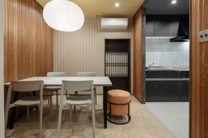 a dining room with a table and chairs and a kitchen at ZOPA Nishicho in Kanazawa