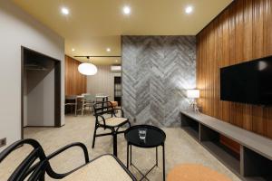 a living room with a tv and chairs at ZOPA Nishicho in Kanazawa