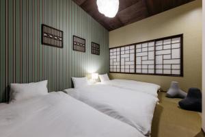 two beds in a room with green walls at ZOPA Nishicho in Kanazawa
