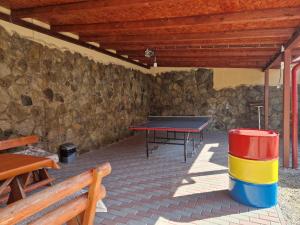 a ping pong table in a patio with a stone wall at Pensiunea Sanlex in Bicaz