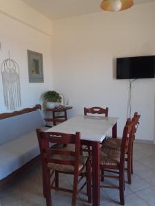 a dining room with a table and chairs and a couch at M. Houses 3 in Agios Romanos