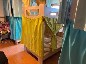a bunk bed with a yellow sheet on it at Okunikko Guesthouse JUN in Nikko
