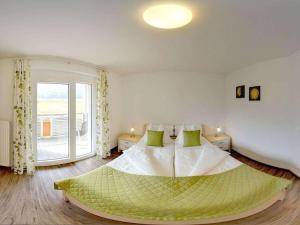una camera da letto con un letto grande con cuscini verdi di 1 at Lake Faak - Karglhof - South view a Faak am See