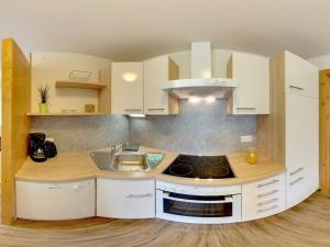 una cucina con mobili bianchi e un lavello di 1 at Lake Faak - Karglhof - South view a Faak am See