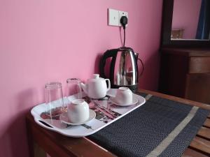 a table with a tea set and a tea kettle at Esha Beach Resort Rooms in Trincomalee