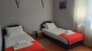 two beds in a small room with a red blanket at Apartments Villa-G Lustica in Tivat