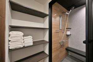 Un baño con ducha a ras de suelo y toallas. en Takeya Gojo, en Kioto 55 fotos más