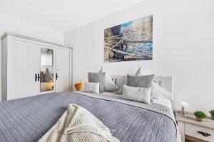 una camera bianca con un grande letto e un dipinto sul muro di DEIN Ostseeblick a Kappeln