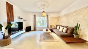 a living room with a couch and a tv at LoerieRoep Estate - Mountainview Selfcatering Accommodation Nelspruit in Nelspruit