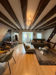 Una gran sala de estar con sofás y una mesa. en Colombages de la Lauch, en Colmar