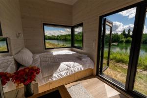 a bedroom with a bed and large windows at Ezy House 2 by Tiny Away in Ézy-sur-Eure