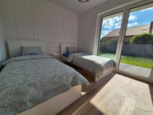 une chambre avec deux lits et une grande fenêtre dans l'établissement Apartament Sportowa przy SUNTAGO DEEPSPOT Mszczonów, à Mszczonów