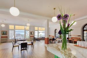 a lobby with tables and chairs and a vase of purple flowers at J5 Hotels Helvetie & La Brasserie in Montreux +18 photos