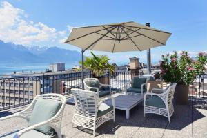 a patio with chairs and a table and an umbrella at J5 Hotels Helvetie & La Brasserie in Montreux