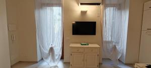 a room with two white curtains and a television at Bordighera Castello Selva Dolce in Bordighera