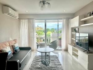 a living room with a couch and a table at Baan Sabai Rama IV Apartment in Bangkok