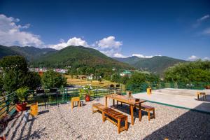 a park with benches and a view of mountains at The Jungalow by AVVAs Stays in Bīr