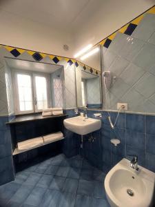 a blue tiled bathroom with a sink and a mirror at La Corte di Atrani in Atrani +26 photos