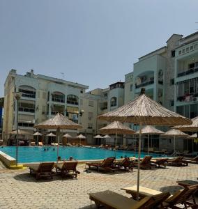 un complejo con piscina con sillas y sombrillas en Klama Luxury Apartment, en Golem