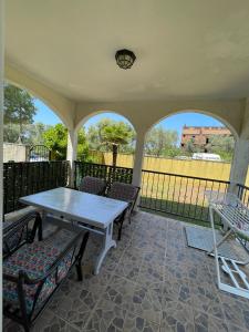 a porch with a table and chairs and a fence at Apartments Villa-G Lustica in Tivat