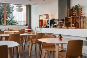 a restaurant with tables and chairs and a counter at Home Swiss Hotel in Geneva