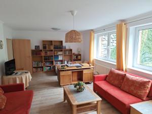 a living room with a red couch and a table at Wohlfühlapartment in Minden in Minden