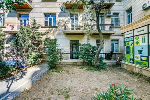 an apartment building with a yard in front of it at Azneft Garden Apartment in Baku