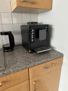 a black microwave sitting on a counter in a kitchen at By Stelwag in Bermatingen