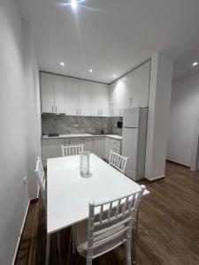 cocina con mesa blanca y nevera blanca en Klama Luxury Apartment, en Golem