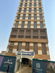 a tall building with a sign in front of it at Sama Al Amany Hotel in Makkah