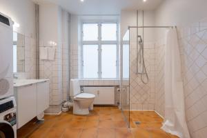 ein Badezimmer mit Toilette und Glasdusche in der Unterkunft Stunning 5 BR Apartment by The Lakes in Kopenhagen