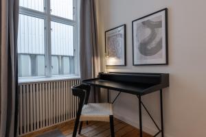 ein schwarzes Klavier in einem Zimmer mit Fenster in der Unterkunft Stunning 5 BR Apartment by The Lakes in Kopenhagen