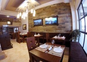 a restaurant with wooden tables and chairs and a tv on a brick wall at Hotel Boutique in Guayaquil