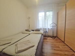 two twin beds in a room with a window at Clarissa Apartman Eger in Eger