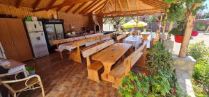 an outdoor restaurant with wooden benches and a refrigerator at La Stefi in 2 Mai