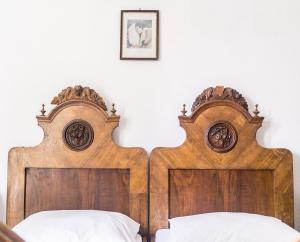 two wooden beds in a bedroom with white sheets at Giunio house, Old town centre in Korčula