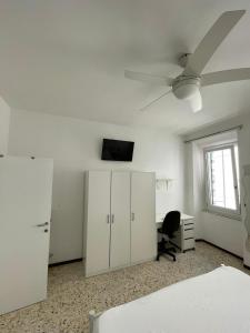 una camera vuota con un letto e un ventilatore a soffitto di La Scala a Chiocciola a San Benedetto del Tronto