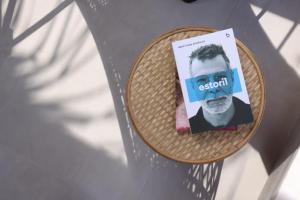 ein Buch auf einem Rattantisch in der Unterkunft Blue Sand Apartment in Pefkohori