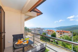 a balcony with a table with food on it at Camille in Rabac