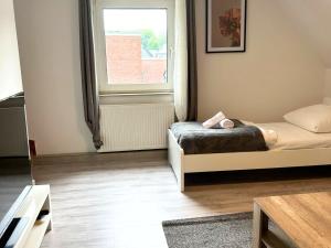 une petite chambre avec un lit et une fenêtre dans l'établissement Stay Nest Komfort Ferien- und Monteurwohnungen Küche-Garten, à Liesborn