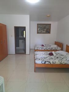 a bedroom with two beds and a door in it at Casa inflorita camere in Eforie Nord