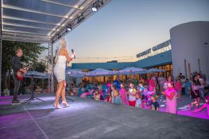 a woman on a stage in front of a crowd of children at Mera Holiday Resort in Venus