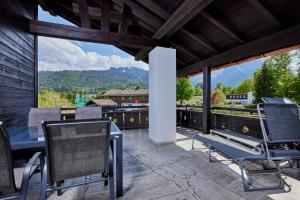 a patio with chairs and a table and some mountains at Heimatliebe in Garmisch-Partenkirchen