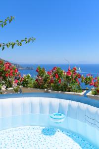 a white bench with flowers and the ocean in the background at Villa Cristina -No steps-Amalfi Coast Views -Hot tube in Praiano
