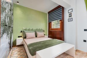 a bedroom with a bed with a green wall at Lous House in Agia Paraskevi +30 photos