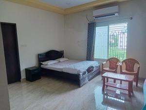 una camera da letto con un letto, una finestra e un tavolo di Govinda Krishna Comforts a Mysore