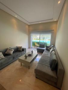 een woonkamer met een bank en een salontafel bij Kettani Bouznika Hind in Bouznika +3 foto's