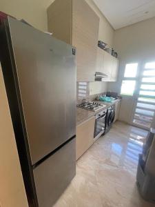 een keuken met een grote roestvrijstalen koelkast bij Kettani Bouznika Hind in Bouznika